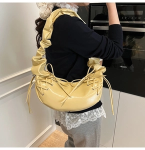Détail du sac croissant jaune pâle avec bandoulière plissée et nœuds latéraux décoratifs