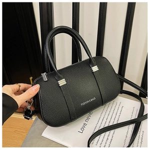 Detail of black litchi texture leather bag with silver hardware and fashion slogan