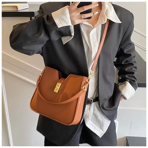 Detail of caramel leather bucket bag with gold square twist lock and V-shaped top edge