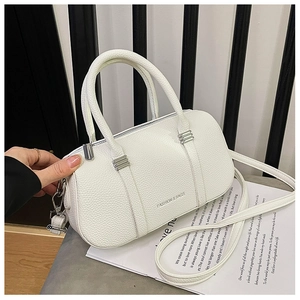 Detail of white lychee grain leather handbag featuring silver hardware and a removable strap