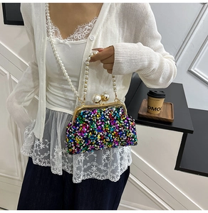 Détail d'un sac de soirée à paillettes avec cadre doré et grand fermoir en perles