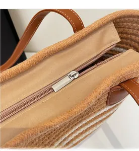 Détail du sac cabas tissé avec fermeture éclair fluide et poignée en similicuir marron