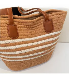 Détail du sac cabas tissé avec rayures marron et blanc et poignées en similicuir