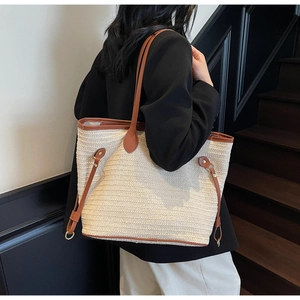 Detail of minimalist woven tote bag with brown leather straps and spacious interior
