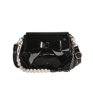 Chic black patent leather crossbody bag with oversized bow and elegant pearl chain strap