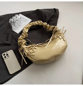Détail du sac hobo beige montrant la poignée plissée et les éléments de cordon tressé