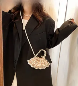 Detail of fan-shaped pearl woven bag with champagne satin drawstring liner and chain