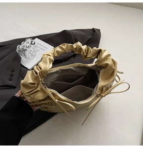 Détail du sac plissé crème montrant la doublure intérieure et les poches zippées