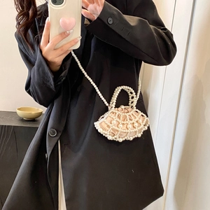 Close-up of fan-shaped pearl evening bag with woven mesh design and champagne satin lining