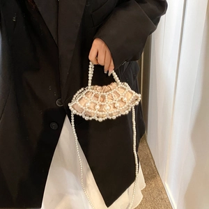 Detail of hand-woven pearl mesh handbag with champagne satin lining and drawstring closure