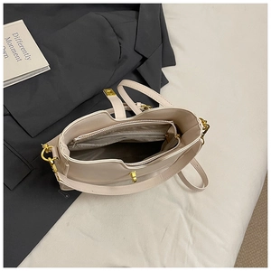Detail view of cream PU leather handbag with internal zip compartments and gold lock