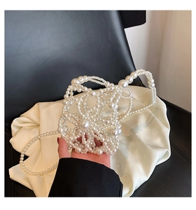Detail of handmade white pearl beaded handbag showing hollow floral woven texture