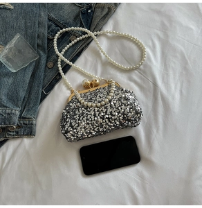 Détail du sac coquillage à paillettes argentées avec fermoir et chaîne en perles