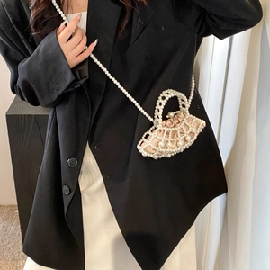 Detail of mini pearl beaded handbag with satin drawstring liner and long strap on model