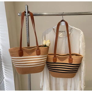 Détail de sacs cabas tissés à rayures avec des anses en cuir marron de qualité
