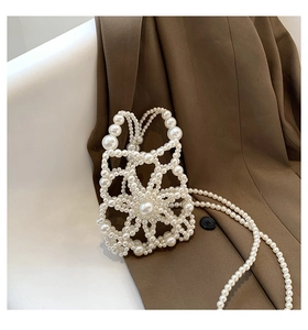 Macro detail of handmade pearl woven flower bag with elegant white crossbody chain strap