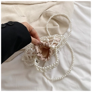 Detailed close-up of handmade pearl woven bag with satin drawstring lining and fine texture
