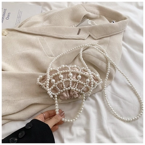 Detailed shot of pearl woven evening bag with champagne satin lining and long strap