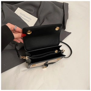 Top view of two-tone crossbody bag with gold magnetic clasp and inner zip pocket detail