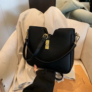 Minimalist black leather underarm bag with gold lock and adjustable shoulder strap