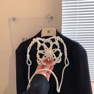 Elegant white handmade pearl body chain with hollow flower patterns on a black blazer