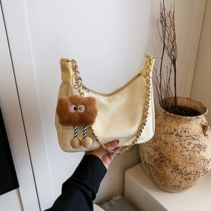 Retro matte beige crescent tote bag with gold chain strap and plush monster charm