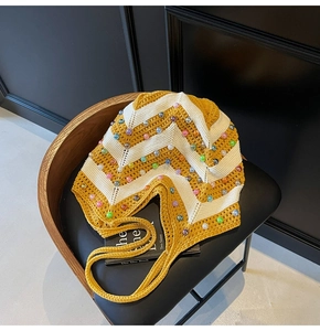 Detail of colorful beads on yellow and beige striped hand-woven crochet crossbody bag