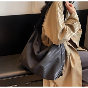 Minimalist black soft leather tote bag shown worn on shoulder for capacity and drape