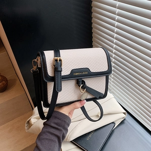 Retro beige tweed crossbody bag with black leather trim and gold pendant detail