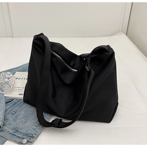 Detail of a black large-capacity tote bag with silver metal zipper and waterproof fabric
