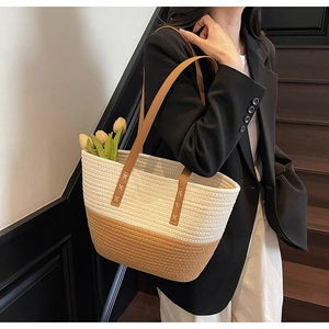 Detail of woven tote bag with bicolor cotton rope design and brown leather straps