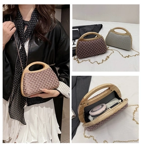Close-up of woven clutch bag with bamboo handle, gold chain strap and interior storage