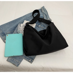 Detail view of the black crossbody bag with adjustable wide strap and matte texture