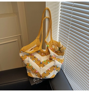 Detail of hand-woven tote bag with yellow V-stripes and colorful faux pearl accents