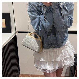 Fashionable jacquard fabric bag with wooden handle and gold chain worn with denim