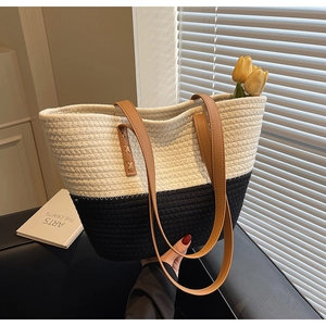 Detail of hand-held woven cotton tote bag with bicolour pattern and leather handles