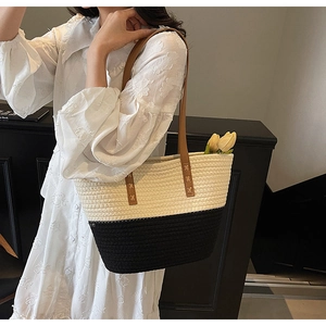 Detail of woven tote bag showing contrasting black and white texture with leather straps