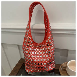 Détail d'un sac cabas rouge avec clous argentés et texture de cuir de haute qualité