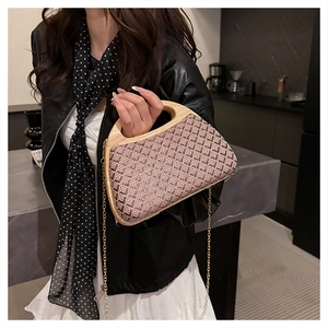 Detail of vintage brown woven clutch with natural wood handle and gold chain strap
