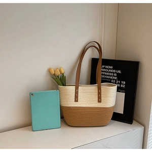 Close-up of woven cotton tote bag with two-tone design and reinforced leather handle straps