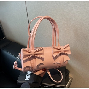 Detail of pink cylinder handbag with large bows and detachable shoulder strap