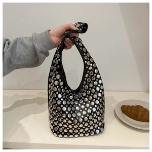 Détail d'un sac hobo noir style punk avec rivets métalliques argentés et clous ronds