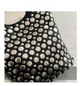 Gros plan détaillé du sac en cuir noir avec décoration de rivets métalliques argentés