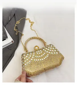 Close-up of sparkling rhinestone evening bag with pearl clasp and golden handle detail