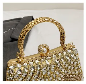 Detail of evening clutch bag featuring rhinestone tassels and pearl clasp on gold frame