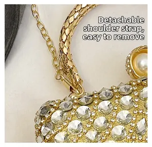 Detail of golden rhinestone evening bag with detachable chain strap and pearl handle