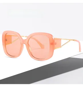 Detail of square peach sunglasses with gold hollow triangular geometric metal temples