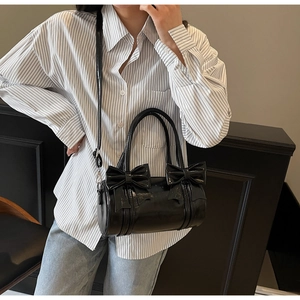 Niche black bow cylinder handbag shown as a crossbody bag on a model for casual daily wear