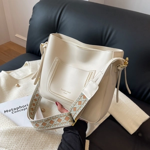 Chic off-white bucket bag with litchi texture and stylish patterned wide shoulder strap