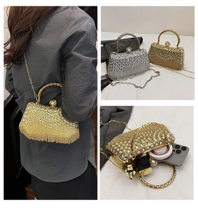 Detail of rhinestone evening bag with sparkling tassels, pearl clasp, and metal chain strap
